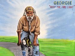 10B Mural of Georgie (No Woman No Cry - And then Georgie would make the fire light) riding a bicycle at the Bob Marley Museum Kingston Jamaica